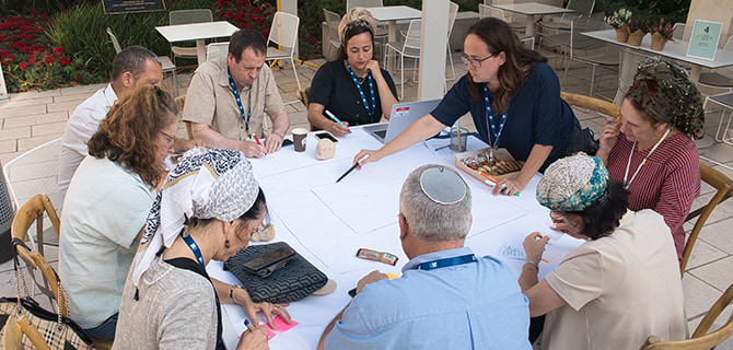 משתתפים יושבים סביב שולחן עגול