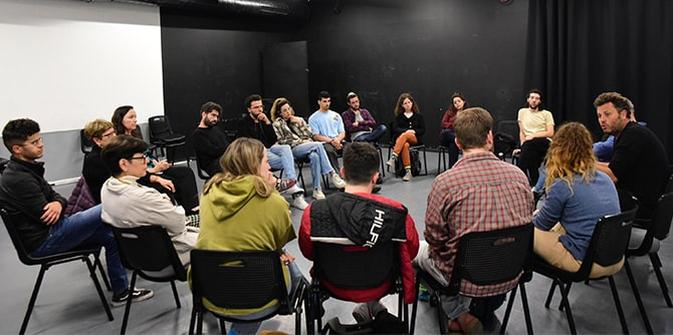A circle of artists and students discussing the issue