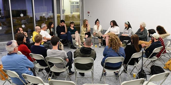 A circle of panelists and students discussing the issue